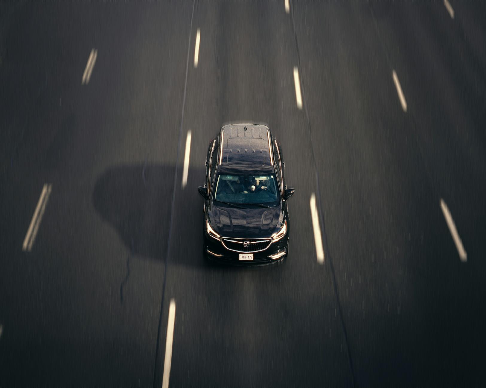 Czarny samochód na nowej drodze ekspresowej widziany z lotu ptaka