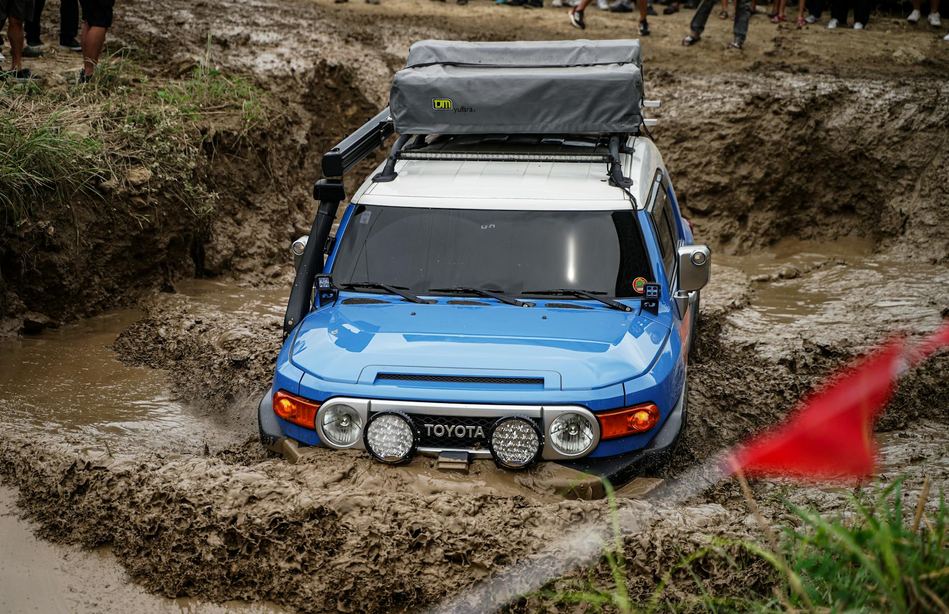 Niebieski Land Rover jedzie po błotnistym terenie podczas wyprawy off-roadowej
