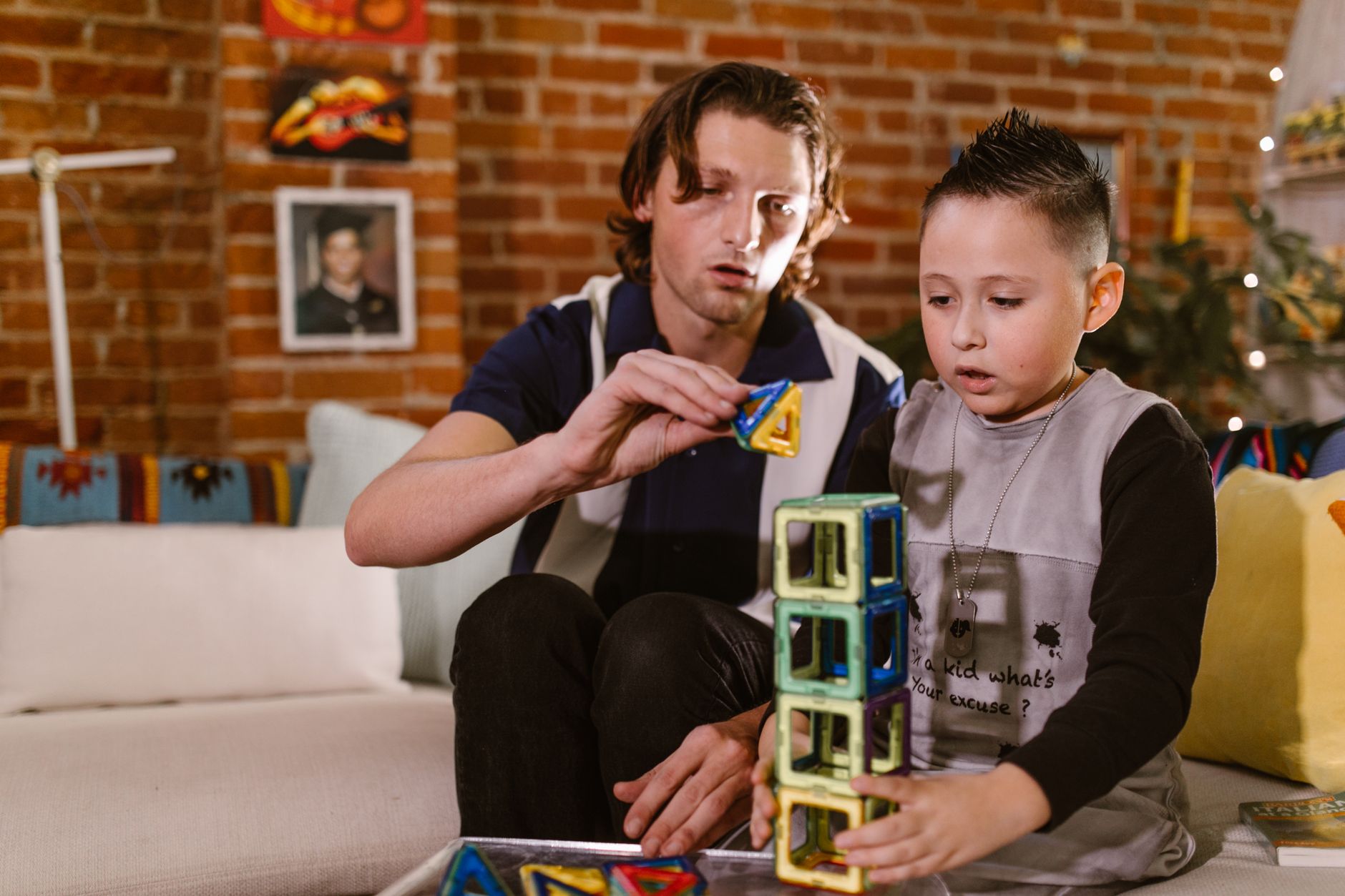 Ojciec i syn bawią się w domu edukacyjnymi magnetycznymi klockami