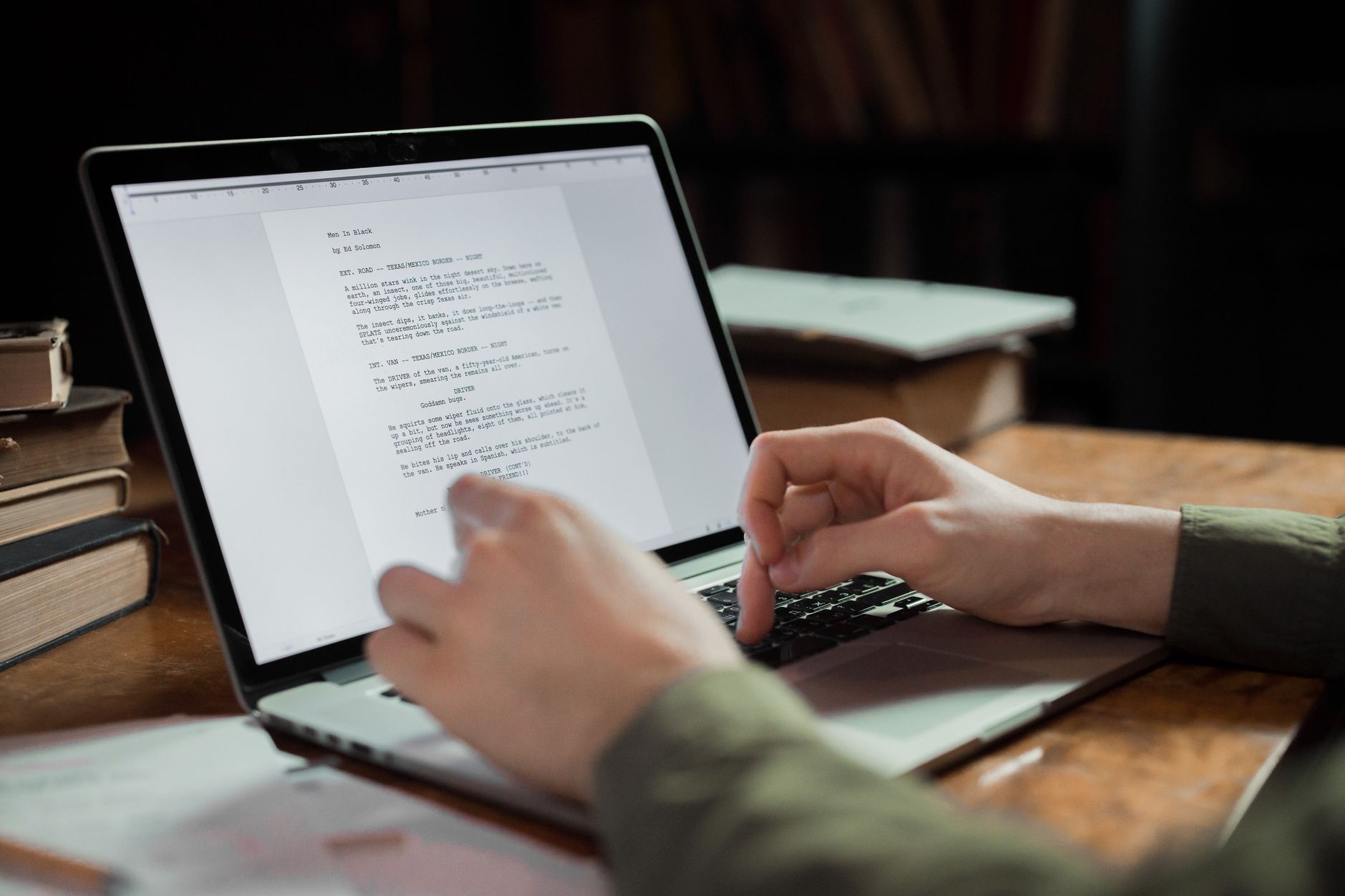 Redakcja i korekta dla self publishera: harmonogram od pierwszego draftu do publikacji Autor self-publisher pisze na laptopie w przytulnym biurze z książkami